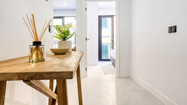 A hallway with a wooden table, a potted plant, and a bottle of reed diffuser. - Beco Santa Emilia 2I, a Home in Madeira (Funchal)