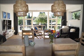 A dining area with a table, chairs, and a vase of flowers.