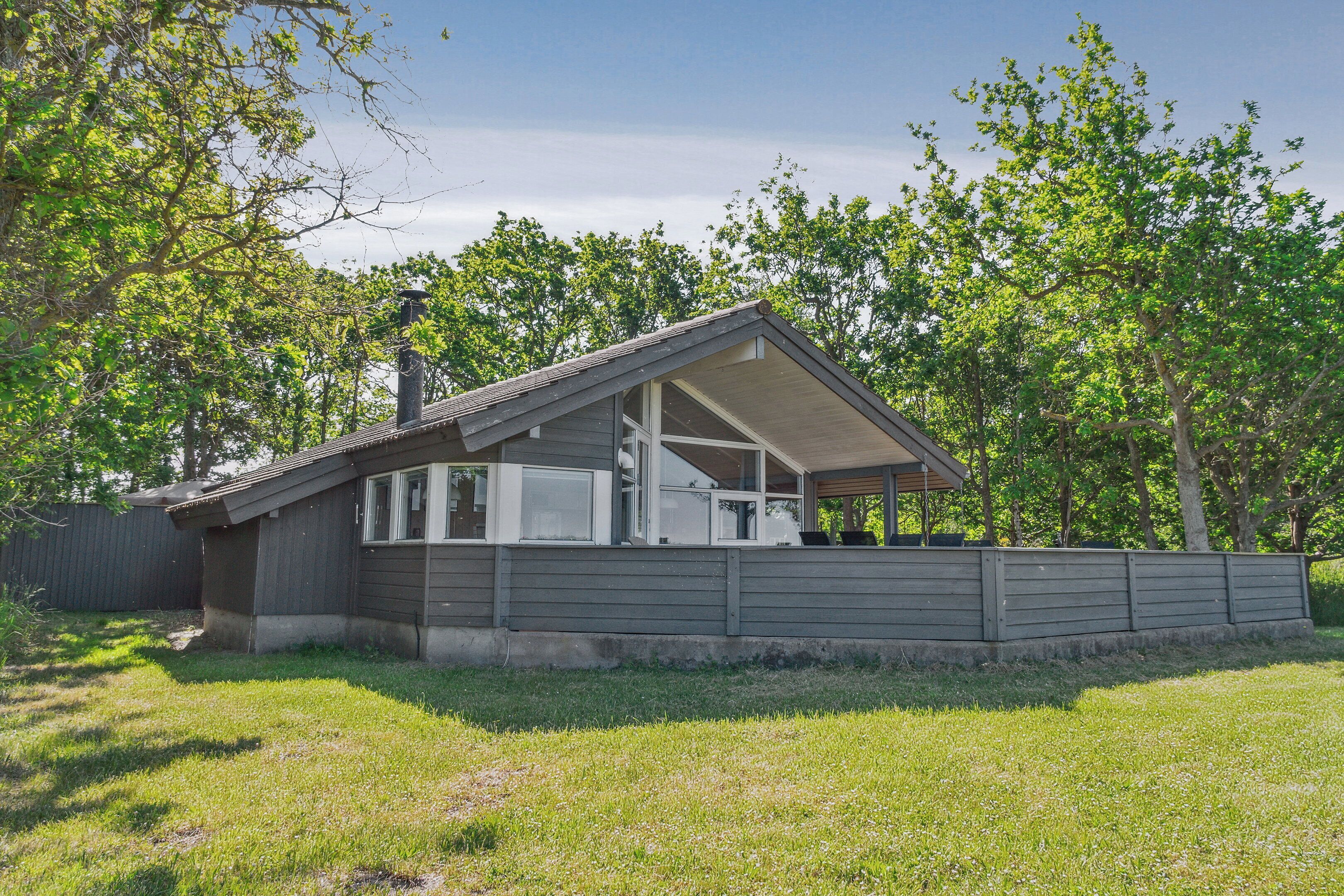 A single-story house with a sloped roof, large windows, and a covered porch.