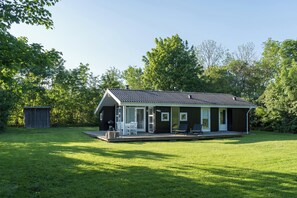A single-story house with a covered patio, a small shed, and a lawn. - Charming house in the heart of WestZealand (Eskebjerg)