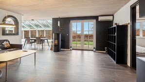 A modern interior with a dining area, fireplace, and large windows.