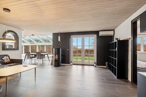 A modern interior with a dining area, fireplace, and large windows.
