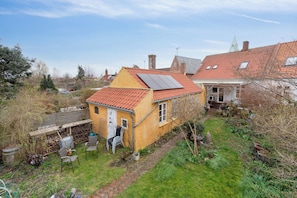 A residential property with a red-tiled roof, a small garden with a paved path, and a white door. - Lovely holiday apartment in Rønne (Rønne)