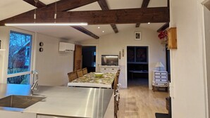 Una cocina moderna con una isla central, un comedor y vistas al exterior.