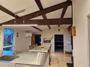 A modern kitchen with a central island, a dining area, and a view of the outside. - Quiet area 15 km to the beach (Skibby)