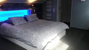 A bedroom with a bed, a wall-mounted light, and motivational posters. - Maison de Vacance a 10 min du Circuit de spa Francorchamps et 5min de Spa (jalhay)