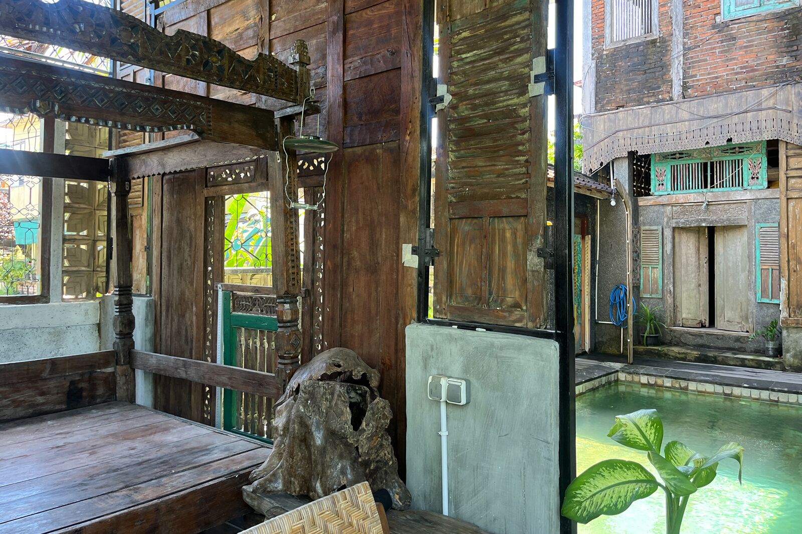 Un intérieur rustique en bois, avec un banc, une structure décorative en bois et un petit élément d’eau ornemental.
