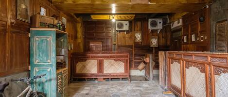 A rustic wooden interior with a stone floor, wooden furniture, and air conditioning units.