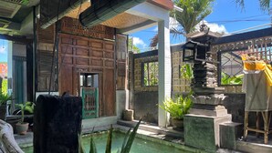 A traditional courtyard with a pool, wooden structures, and potted plants. - TwoSpaces Living at Bunga Desa Jimbaran (Jimbaran)