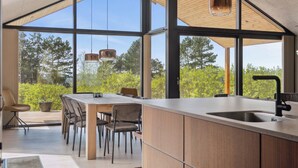 A modern kitchen with a large island, wooden cabinetry, and a view of the outdoors. - Impressive holiday cottage, by the Helsnæs Bay! (Millinge)