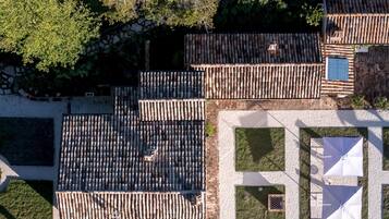 Traditional courtyard with lush greenery and rustic wooden structures.