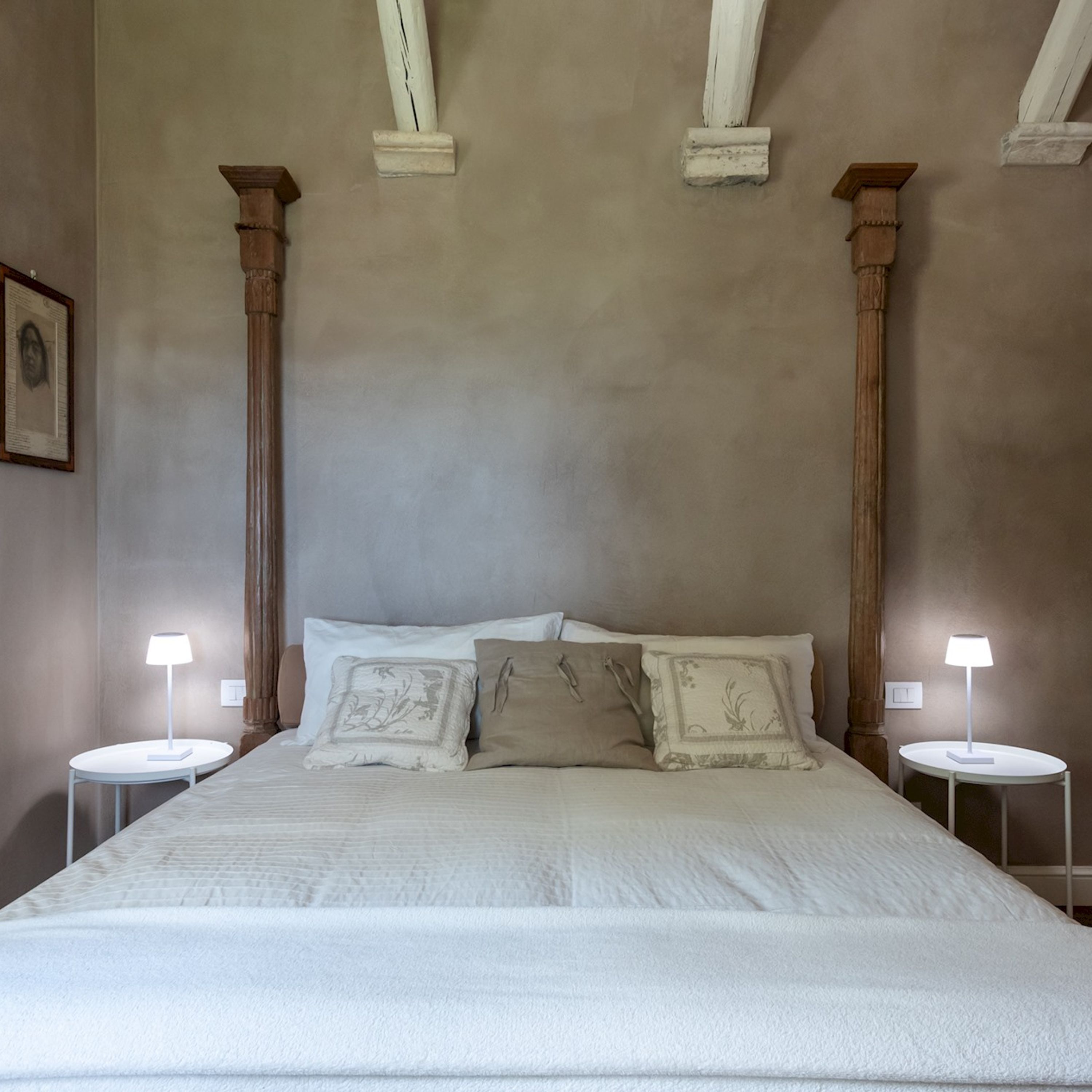 Un dormitorio con una cama grande, dos mesitas de noche y un cuadro enmarcado en la pared.