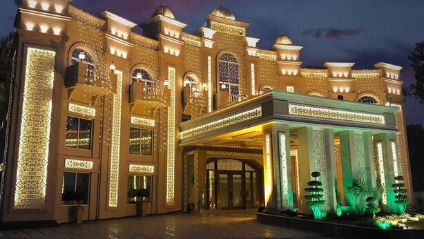 A grand hotel with a large entrance, multiple arches, and decorative lighting. - Devrath By Big Bite Resort (Meerut)