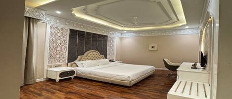 Un dormitorio con una cama grande, una mesita de noche, un aparador y una silla.