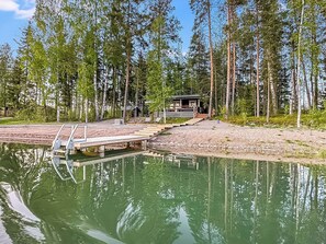 A lakeside cabin with a dock extending into the water, surrounded by tall trees. - Valkjärvi 2 by Interhome (Iitti)