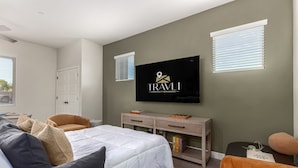 A bedroom with a bed, a TV mounted on the wall, a desk, and a chair. - Macallister Luxe 1008 | Close to Golf |Heated Pool (Scottsdale)