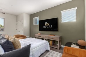 A bedroom with a bed, a TV mounted on the wall, a desk, and a chair. - Macallister Luxe 1008 | Close to Golf |Heated Pool (Scottsdale)