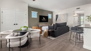 A modern living room with a sofa, chairs, a TV, and a ceiling fan. - Macallister Luxe 1008 | Close to Golf |Heated Pool (Scottsdale)