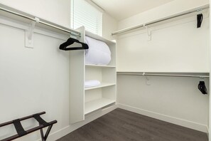 A walk-in closet with white walls, a wooden floor, and a hanging rod. - Macallister Luxe 1008 | Close to Golf |Heated Pool (Scottsdale)