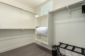 A walk-in closet with open shelving, a hanging rod, and a trash bin. - Macallister 2006|Close to Golf|Htd Pool|BBQ (Scottsdale)