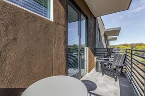 A balcony with a table and chairs, a view of the landscape, and a building with a textured wall. - Macallister 2006|Close to Golf|Htd Pool|BBQ (Scottsdale)