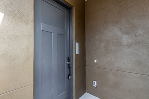A gray door with a keypad lock, a wall-mounted mailbox, and a textured wall. - Macallister 2008|Heated Pool|Close 2 Golf|BBQ|View (Scottsdale)