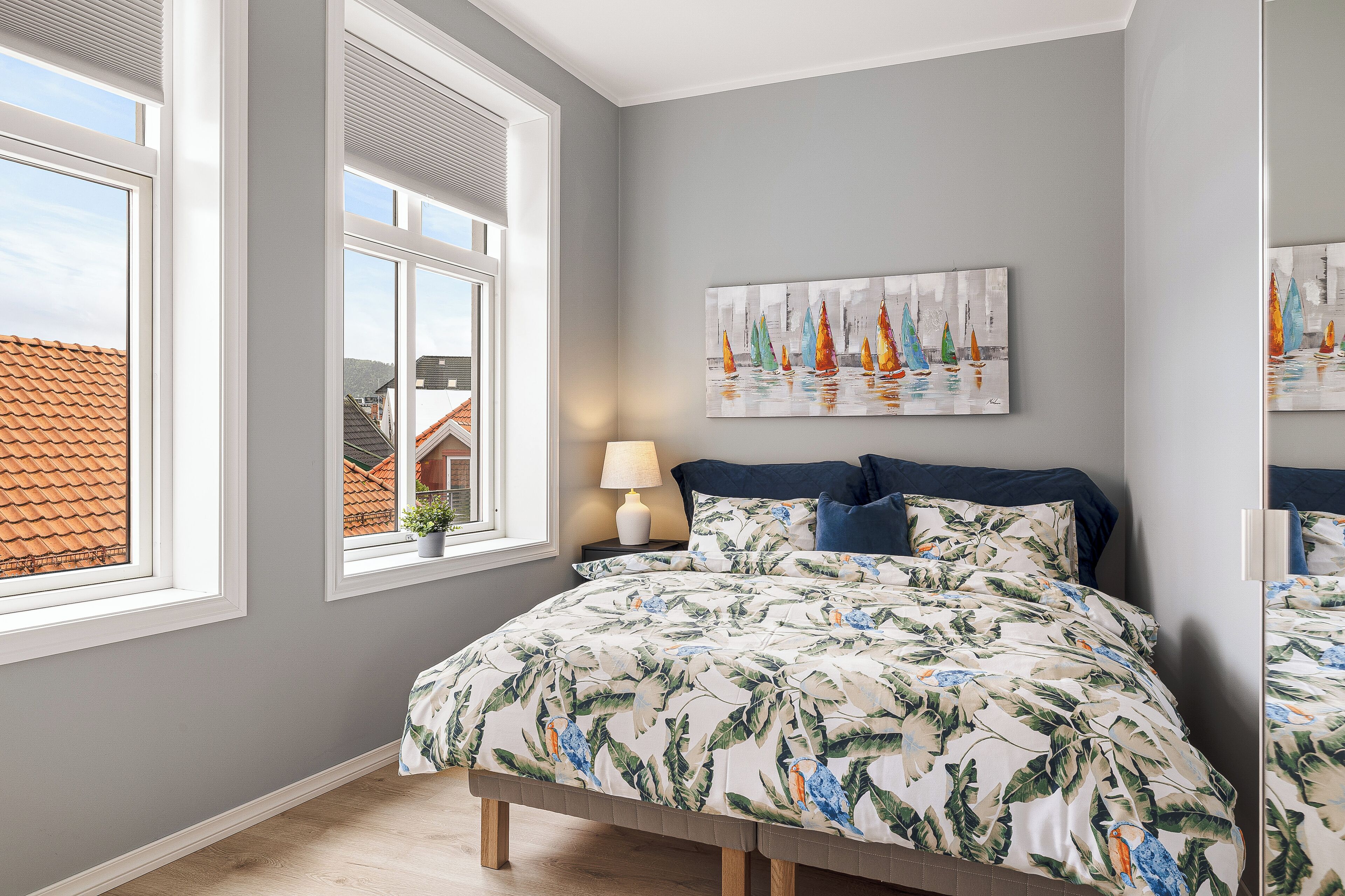 Une chambre à coucher avec un lit, une fenêtre et un tableau accroché au mur.