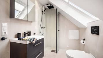 A modern bathroom with a skylight, a shower, and a toilet.