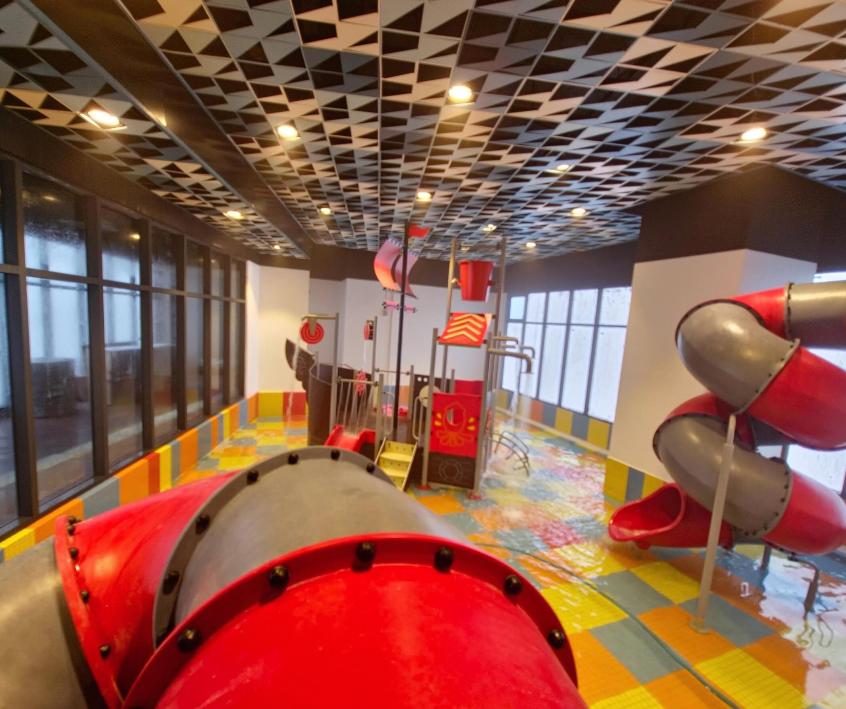 A play area with slides and a colorful floor.