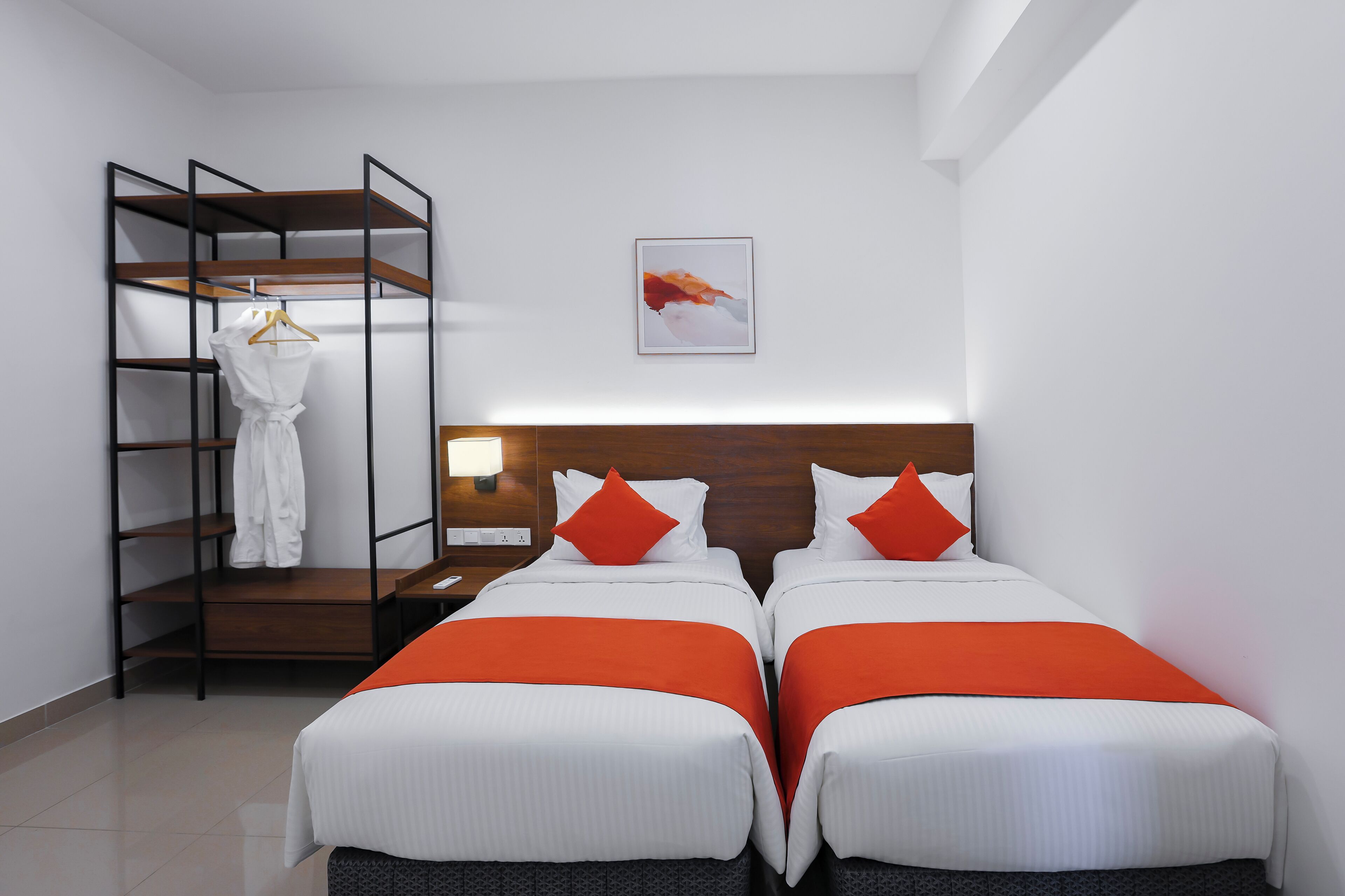 Une chambre d’hôtel avec deux lits, une armoire et un tableau au mur.