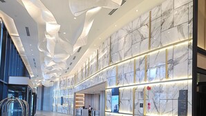 A modern hotel lobby with marble walls, a reception desk, and a seating area. - Wyndham Ion Majestic Genting Highlands (Genting Highlands)