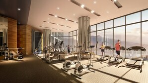 A modern gym with various exercise equipment, large windows offering views of the outdoors, and a spacious layout. - Wyndham Ion Majestic Genting Highlands (Genting Highlands)