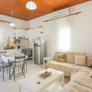 A compact living space with a dining area, kitchenette, and a sofa. - Andromaxi Apt in Gaios (Paxos)