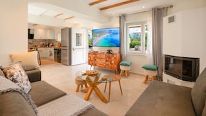 A modern living room with a glass coffee table, a sofa, and a television. - Villa Villekulla in Ionian Islands (Corfu)