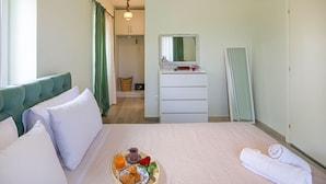 A hotel room with a bed, a dresser, a mirror, and a breakfast tray on the bed. - Villa Villekulla in Ionian Islands (Corfu)