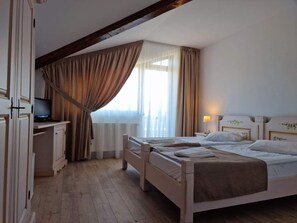 A bedroom with two beds, a desk, and a television. - Complex turistic Panicel (Rasnov)