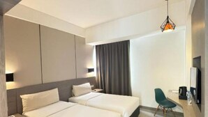 A modern hotel room with two beds, a desk, a chair, and a TV. - Laska Hotel Subang (Subang)