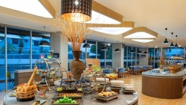 A buffet setup with various food items and a decorative centerpiece. - Laska Hotel Subang (Subang)