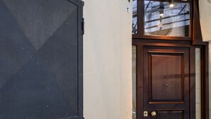 A dark wooden door with a glass panel and a metal handle. - Via Nilo 30 in Naples (Naples)