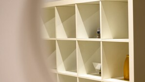 A white, geometric shelving unit with multiple compartments, some containing items. - Via Nilo 30 in Naples (Naples)