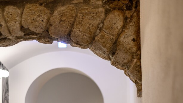 An arched doorway leading to a room with a bed and a nightstand. - Via Nilo 30 in Naples (Naples)