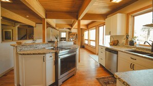 Una cocina amplia con encimeras de granito, piso de madera y una isla grande.