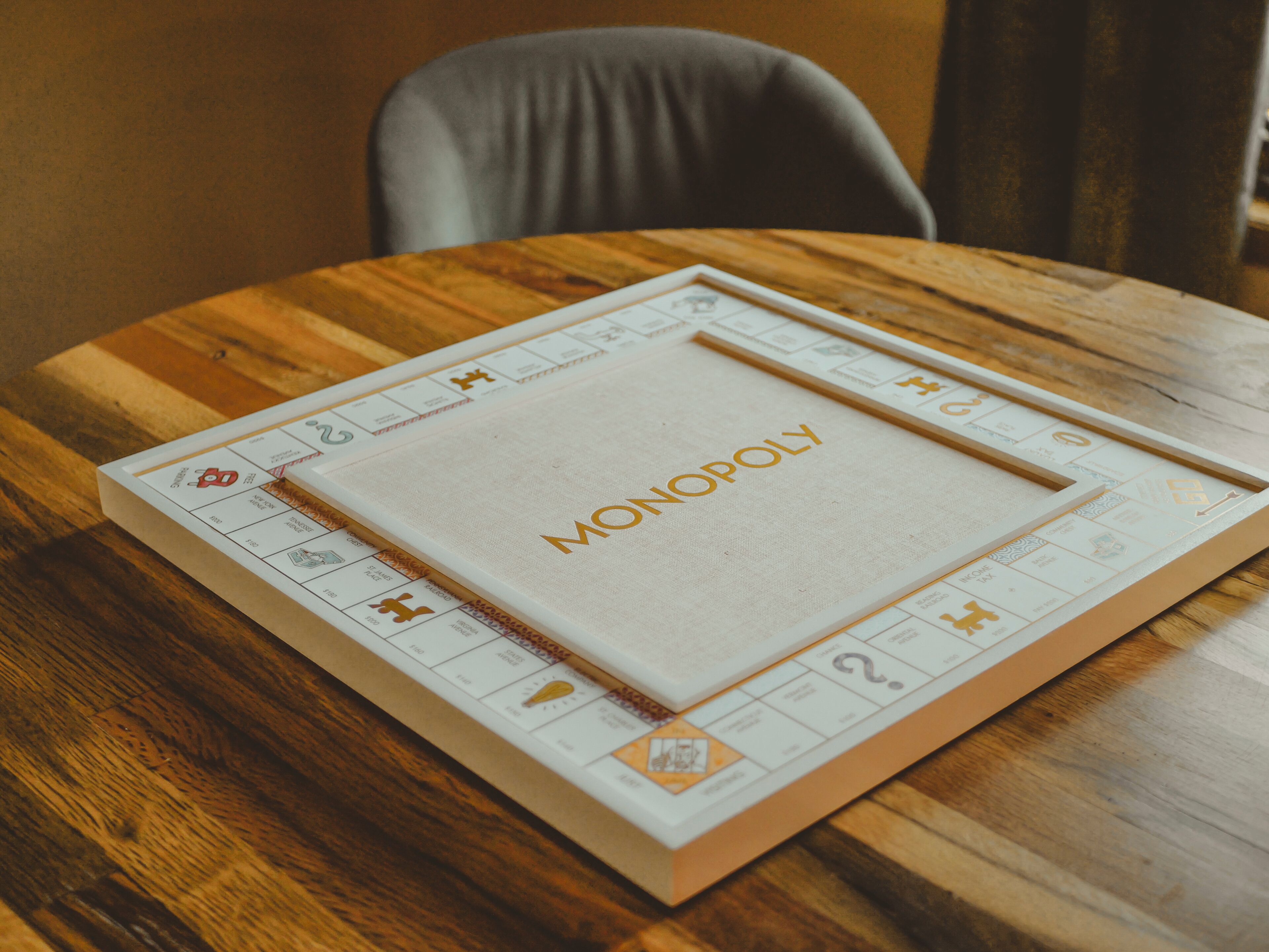 A board game titled MONOPOLY on a wooden table.