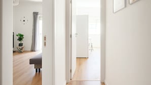 A hallway with wooden flooring, white walls, and a door leading to another room. - Lovely 2 bed apartment in quiet Lisbon South Bay - Close to the best beaches! (Baixa da Banheira)
