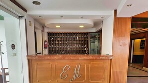 A reception desk with a wooden finish and a glass partition. - Mediterraneo 702. Super Studio with Amazing Sea Views (Marbella)