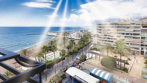 A coastal cityscape with a beach, palm trees, and a large hotel building. - Mediterraneo 702. Super Studio with Amazing Sea Views (Marbella)