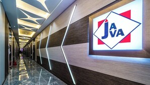 A modern hallway with a polished marble floor, a geometric ceiling design, and a prominent 'JAVA' sign on the wall.