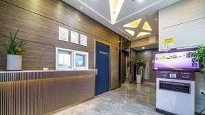 A reception area with a wooden reception desk, a digital kiosk, and a door labeled "Information."