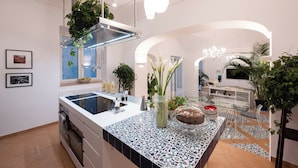 A modern kitchen with a central island, stainless steel appliances, and a variety of plants. - Villa Mare Blu With Sea View (Praiano)