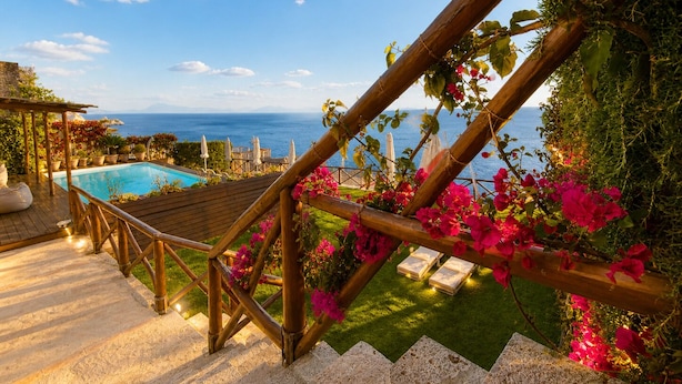 A wooden staircase leading to a pool area with a view of the sea. - Villa Mare Blu With Sea View (Praiano)
